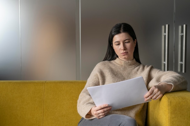 Frau, die alleine arbeitet, während sie sich sozial von anderen Mitarbeitern distanziert