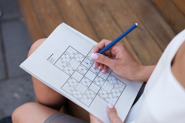 Frau, die alleine ein Sudoku-Spiel genießt