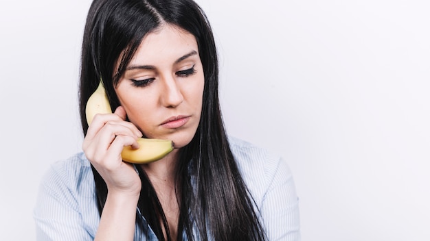 Kostenloses Foto frau, die am bananentelefon spricht