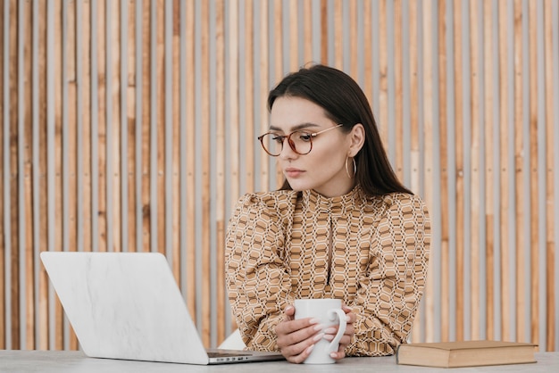 Frau, die am mittleren Schuss des Laptops arbeitet