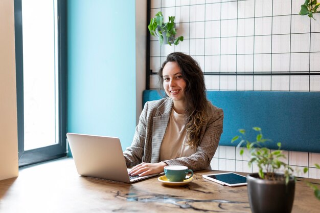 Frau, die am mittleren Schuss des Laptops arbeitet