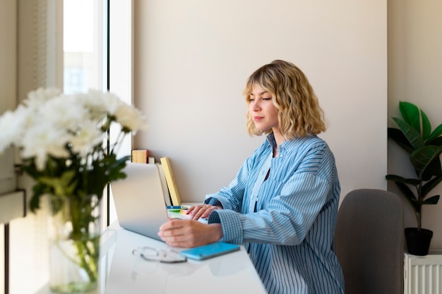 Frau, die am mittleren Schuss des Laptops arbeitet