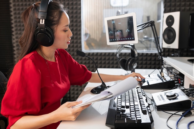 Frau, die am Radio mit professioneller Ausrüstung arbeitet