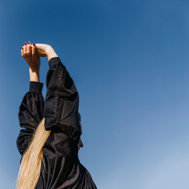 Frau, die am Strand ausdehnt