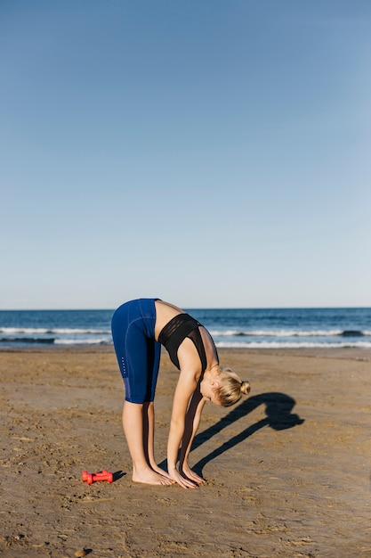 Kostenloses Foto frau, die am strand ausdehnt