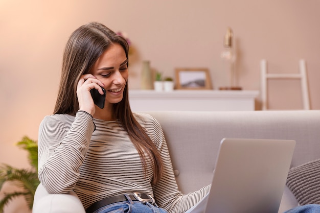 Kostenloses Foto frau, die am telefon spricht und hausaufgaben macht