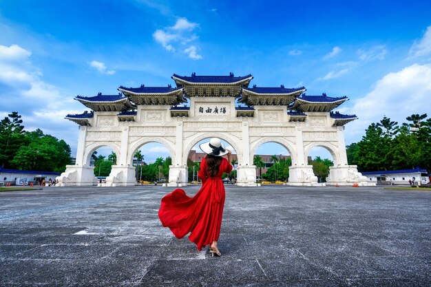 Frau, die am Torbogen der Chiang Kai Shek Memorial Hall in Taipeh, Taiwan geht.