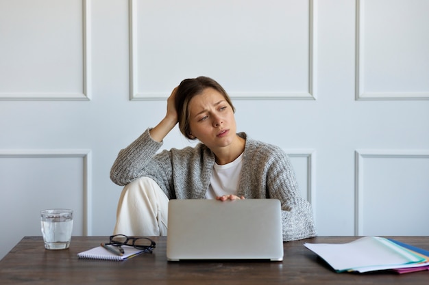 Kostenloses Foto frau, die an der vorderansicht des laptops arbeitet