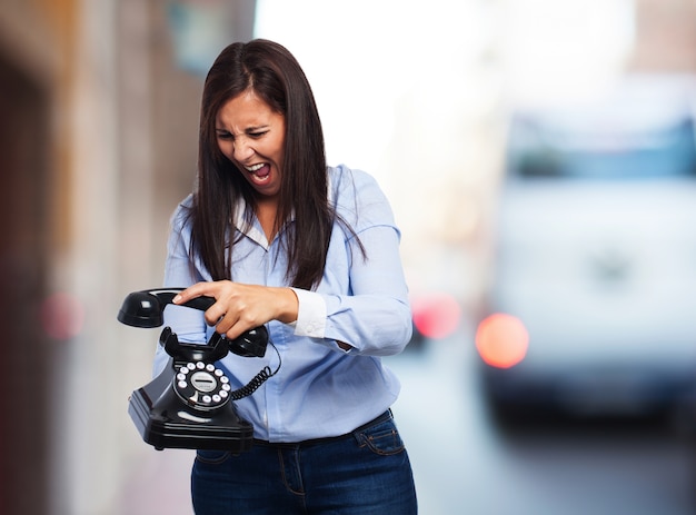 Frau, die an einem antiken Telefon schreit