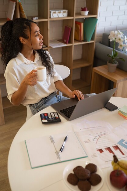 Frau, die an einem hohen Winkel des Laptops arbeitet