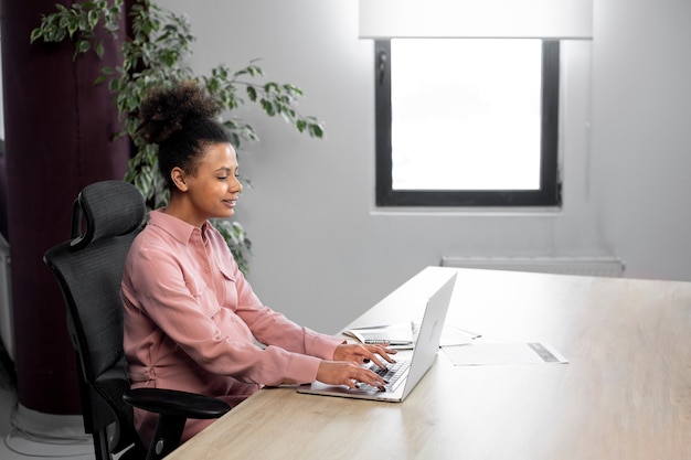 Frau, die an mittlerer Aufnahme des Laptops arbeitet