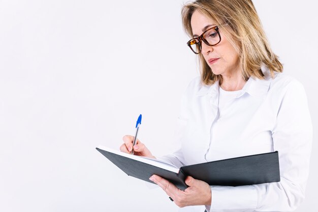 Frau, die Anmerkungen im Notizbuch macht