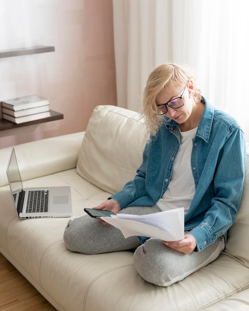 Frau, die auf Couch arbeitet