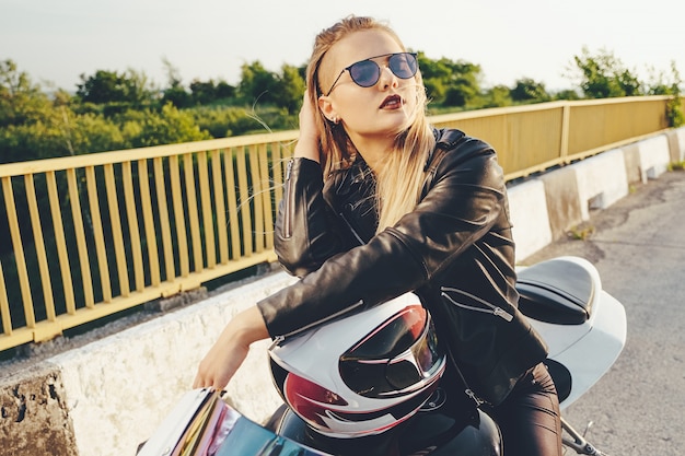 Kostenloses Foto frau, die auf das motorrad trägt moderne sonnenbrille fährt