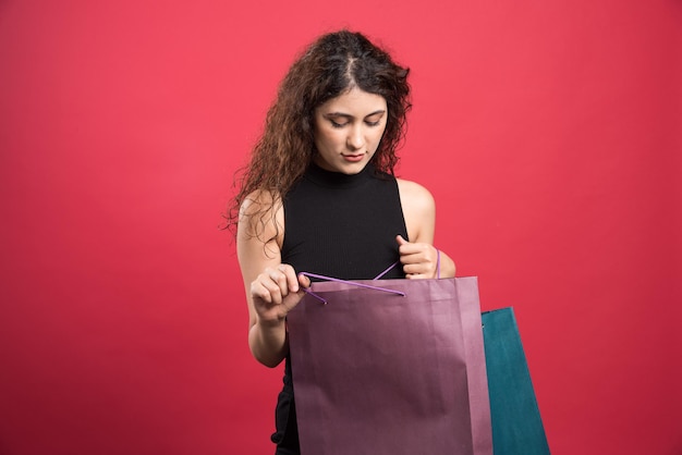 Frau, die auf einem der Tasche auf Rot schaut.