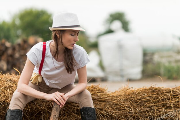Frau, die auf Stroh in einem Bauernhof sitzt