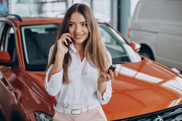 Frau, die Autoschlüssel an ihrem neuen Auto hält