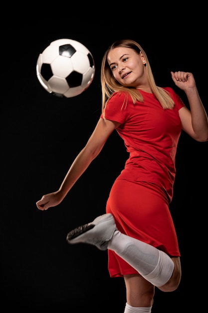 Kostenloses Foto frau, die ball mit fuß tritt