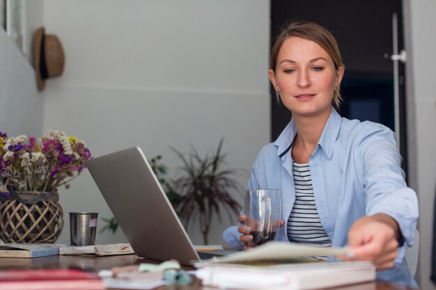 Frau, die Becher und das Arbeiten hält