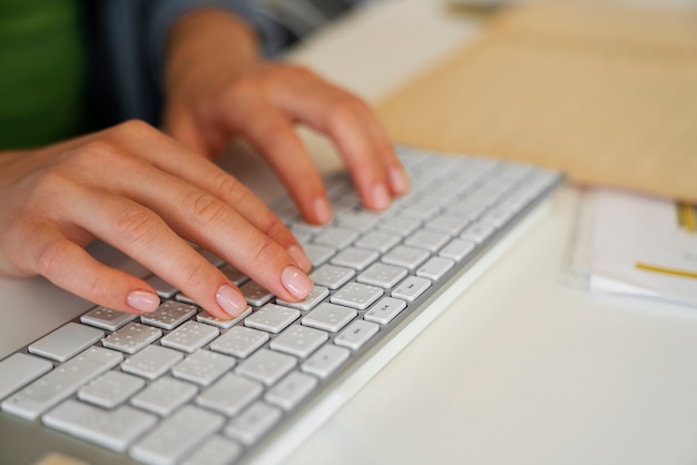 Frau, die bei der Arbeit auf der Tastatur tippt