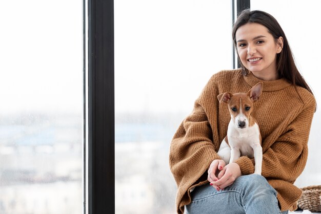 Frau, die beim Halten des Hundes in ihrem Schoß aufwirft