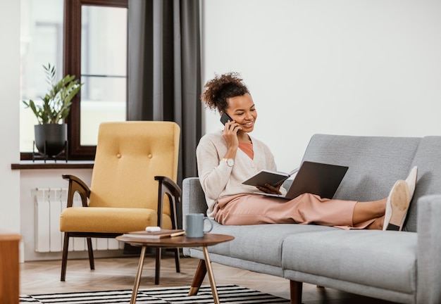 Frau, die beim Sitzen auf dem Sofa arbeitet