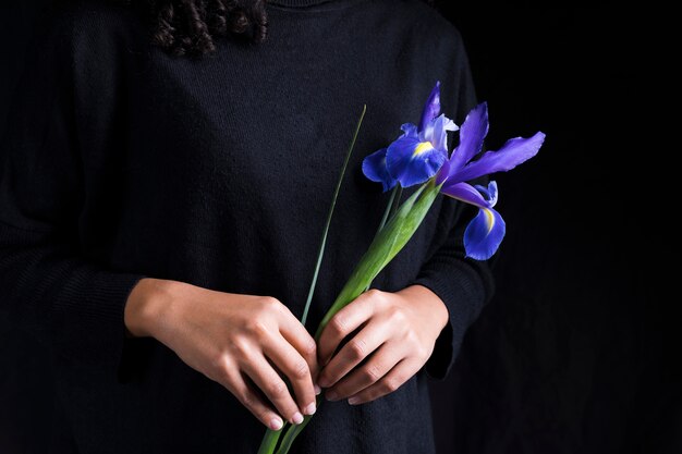 Frau, die blaue Blume in den Händen hält