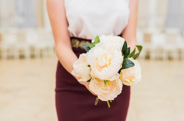 Kostenloses Foto frau, die blumenblumenstrauß in den händen hält