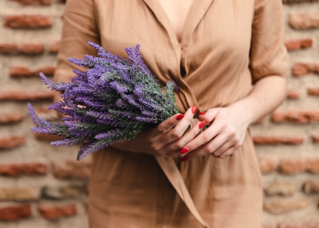 Frau, die Blumenstrauß von Lavendelblumen hält