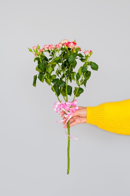 Kostenloses Foto frau, die blumenstrauß von rosen hält