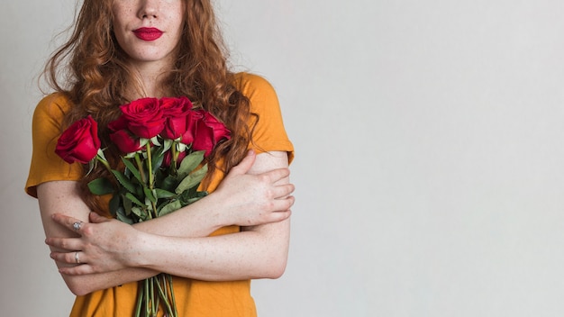 Frau, die blumenstrauß von rosen mit kopienraum hält