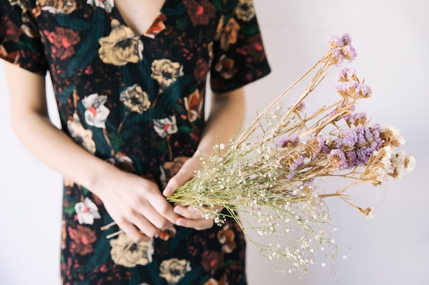 Frau, die Blumenstrauß von trockenen Anlagen hält