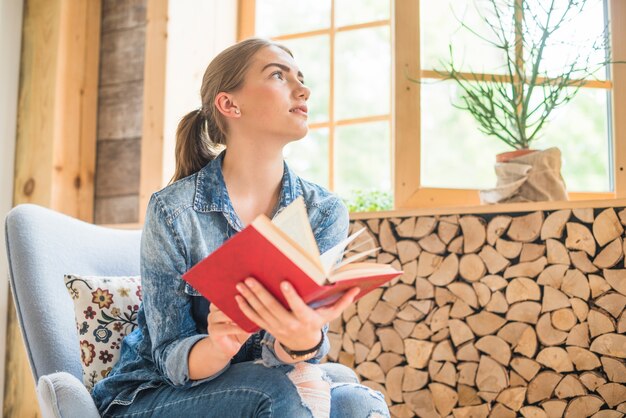 Frau, die Buch beim Denken hält