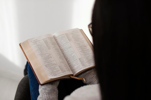 Frau, die die Bibel drinnen liest