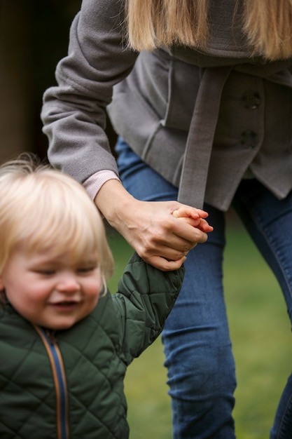 Kostenloses Foto frau, die die hand des kindes in der natur hält