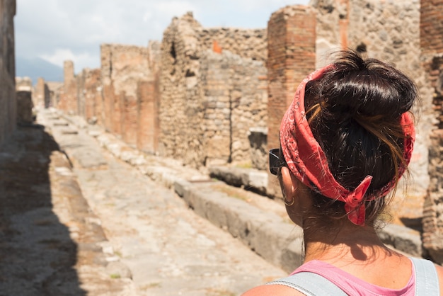 Frau, die die römische archäologische stätte von pompeji in italien beobachtet.