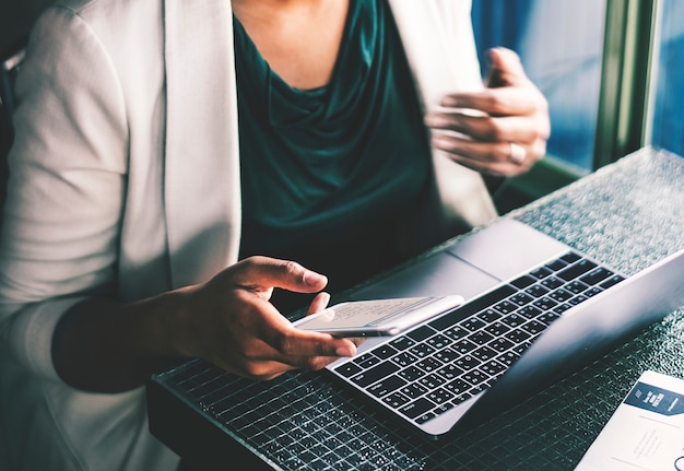 Frau, die digitale Geräte am Café verwendet