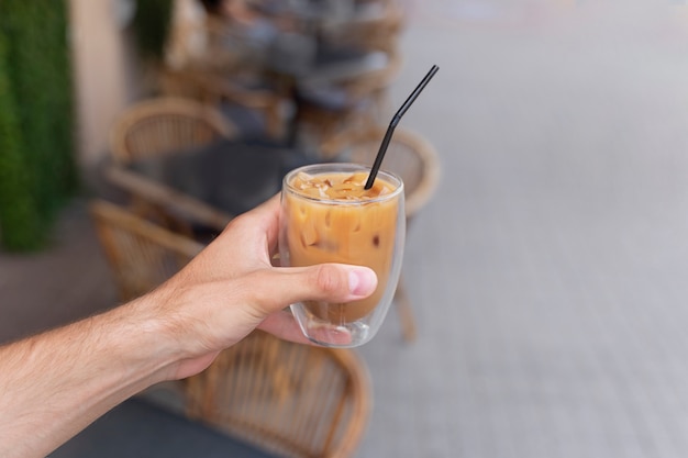 Frau, die draußen eine Eiskaffeepause hat