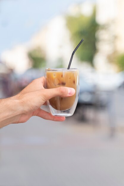 Frau, die draußen eine Eiskaffeepause hat