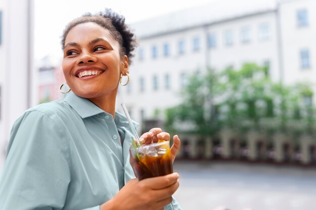 Frau, die draußen eine Eiskaffeepause hat