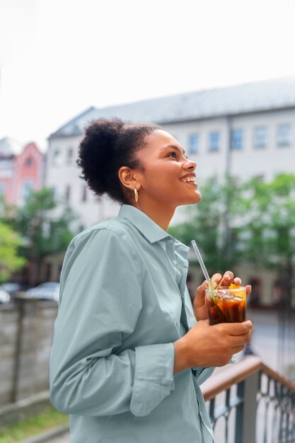 Frau, die draußen eine Eiskaffeepause hat