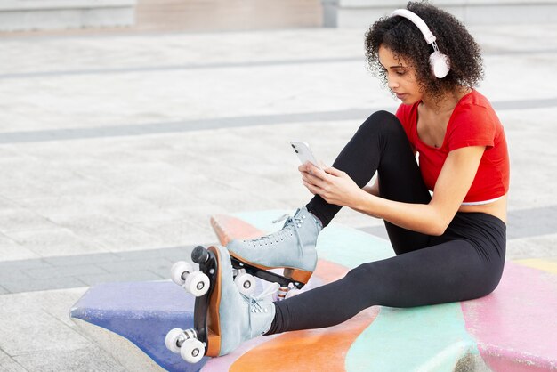 Frau, die draußen Foto ihrer Rollschuhe macht