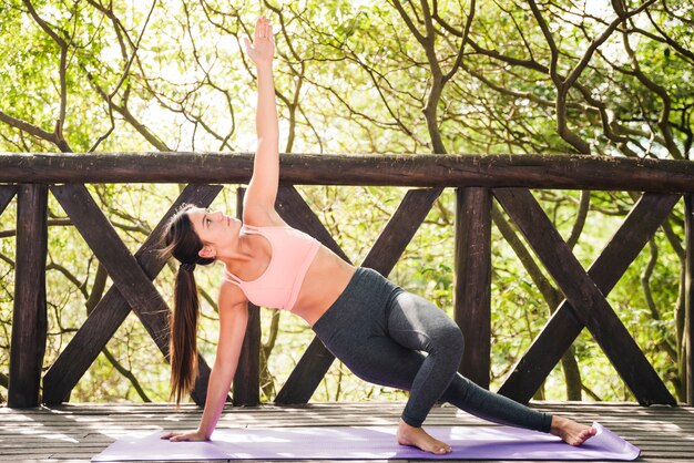 Frau, die draußen Yoga tut