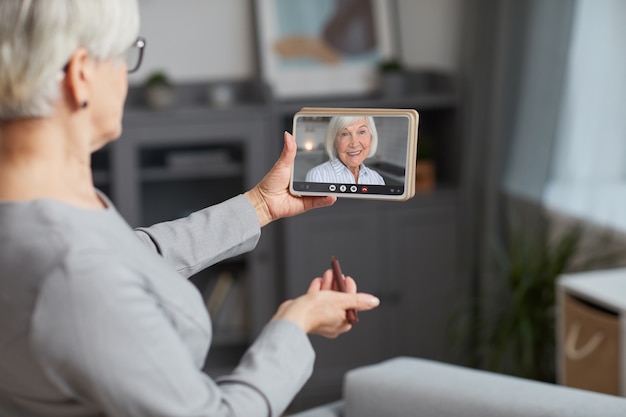 Frau, die drinnen einen Videoanruf tätigt