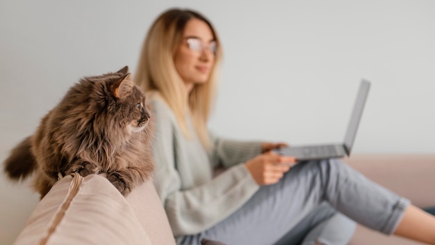 Frau, die drinnen mit ihrer Katze sitzt