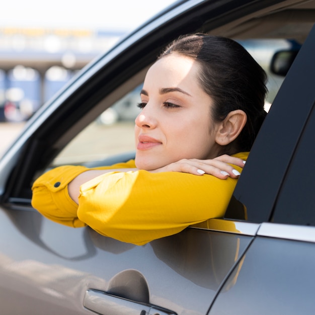 Frau, die durch das Autofenster schaut