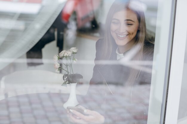 Frau, die durch eine Glas lachen