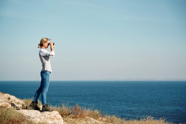 Frau, die durch Fernglas schaut