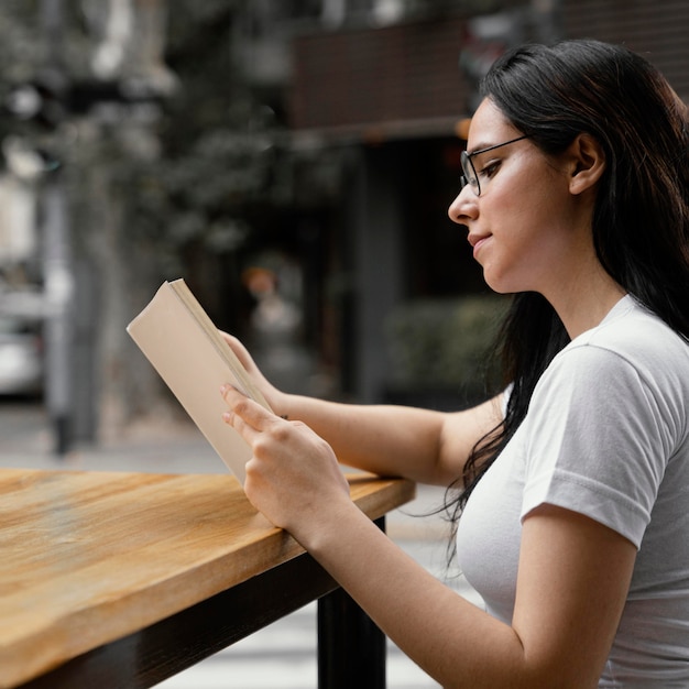 Kostenloses Foto frau, die ein buch allein liest