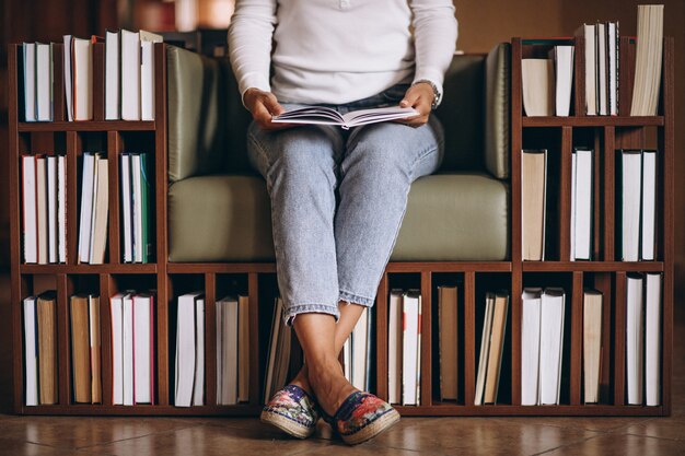 Frau, die ein Buch in einem Stuhl liest